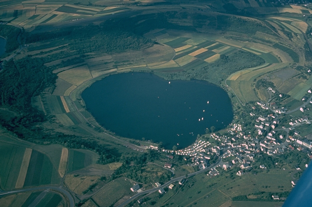 The Schalkenmehren maar is one of about 240 volcanic vents forming the West Eifel volcanic field in western Germany.  The crater, now partially occupied by a lake, farmland, and the town of Schalkenhren, was formed by explosive eruptions through nonvolcanic bedrock that created a low, 1-km-wide crater rim of volcanic ejecta. Copyrighted photo by Katia and Maurice Krafft.