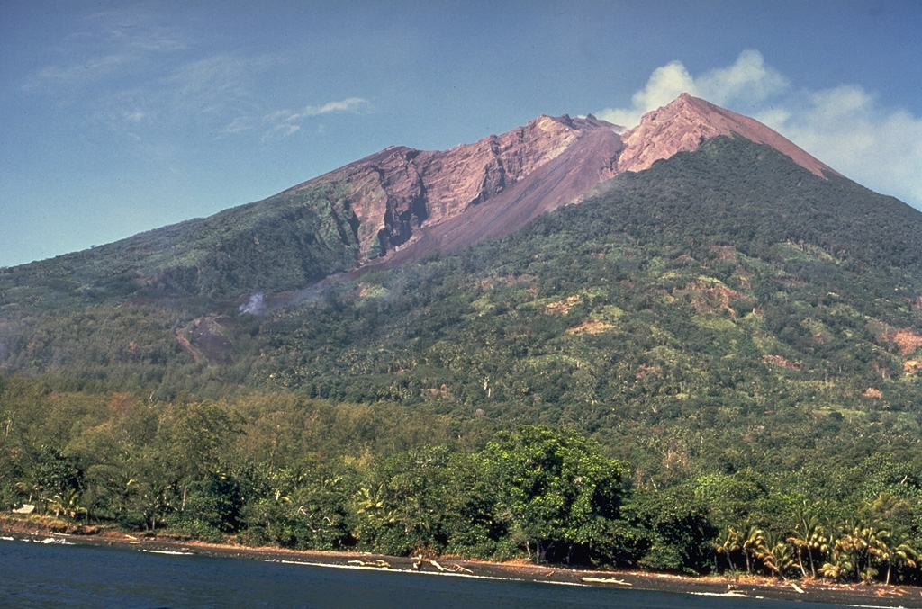 The 10-km-wide island of Manam is one of Papua New Guinea's most active volcanoes. Four large radial valleys extend from the unvegetated summit to its lower flanks and two summit craters are present. Most eruptions during the past century have originated from the southern crater, concentrating eruptive products into the SE avalanche valley, seen here from off the east coast of the island. Frequent eruptions have been recorded since 1616. Photo by Wally Johnson (Australia Bureau of Mineral Resources).