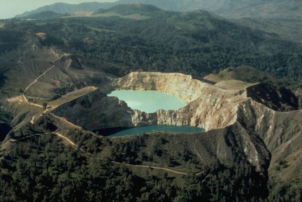 The SE-most pair of Kelimutu's crater lakes, Tiwu Ata Polo and Tiwu Nua Muri Kooh Tai, are seen here in an aerial view from the SE. A light-colored area of upwelling can be seen in the upper lake and this also occurs in the lower one. All three lakes are close to saturation with gypsum/anhydrite, contributing to color variations. Photo by Tom Casadevall, (U.S. Geological Survey).