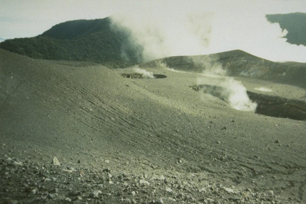 The small craters Kepundan B and C in the foreground, seen here from the N, are two of many historically active craters along the elongated summit of Marapi volcano on Sumatra. A thick plume in the background rises above the westernmost summit crater, Kawah Bongsu. Photo by Gede Suantika, 1993 (Volcanological Survey of Indonesia).