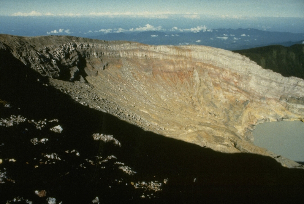 The crater wall of Kawah Merapi, the youngest and NW-most of the craters along the summit of Dempo volcano, is capped by thin lava flows. A crater lake is seen at the lower right in this view from the NE. Gunung Merapi, the high point of the summit region of Dempo volcano, occurs at the extreme left at the SE part of the crater rim. Photo by Ruska Hadian, 1989 (Volcanological Survey of Indonesia).