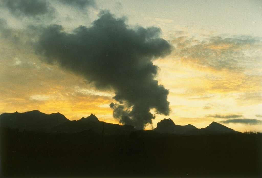 Explosive eruption of Kelud in February 1990 seen from the Volcanological Survey of Indonesia observation post on the west side of the volcano. This eruption emptied the crater lake and produced pyroclastic flows that traveled 7-8 km. A series of lava domes gives the summit of Kelud a broad, irregular profile. Photo by Ruska Hadian, 1990 (Volcanological Survey of Indonesia).