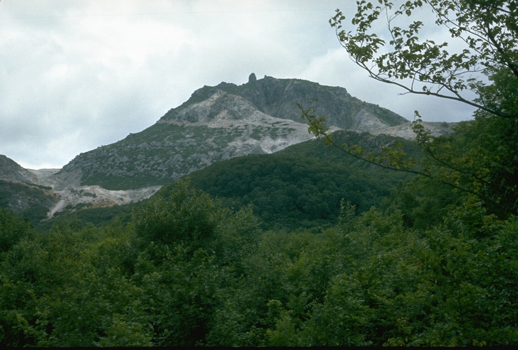 Atosanupuri lava dome was emplaced about 1,000 years ago and its hydrothermally altered flanks are visible in this photo. The 900-m-wide dome was constructed within a 1-km-wide crater. Atosanupuri is one of a cluster of lava domes that occupy the eastern side of Kussharo Caldera. Photo by Lee Siebert, 1977 (Smithsonian Institution).