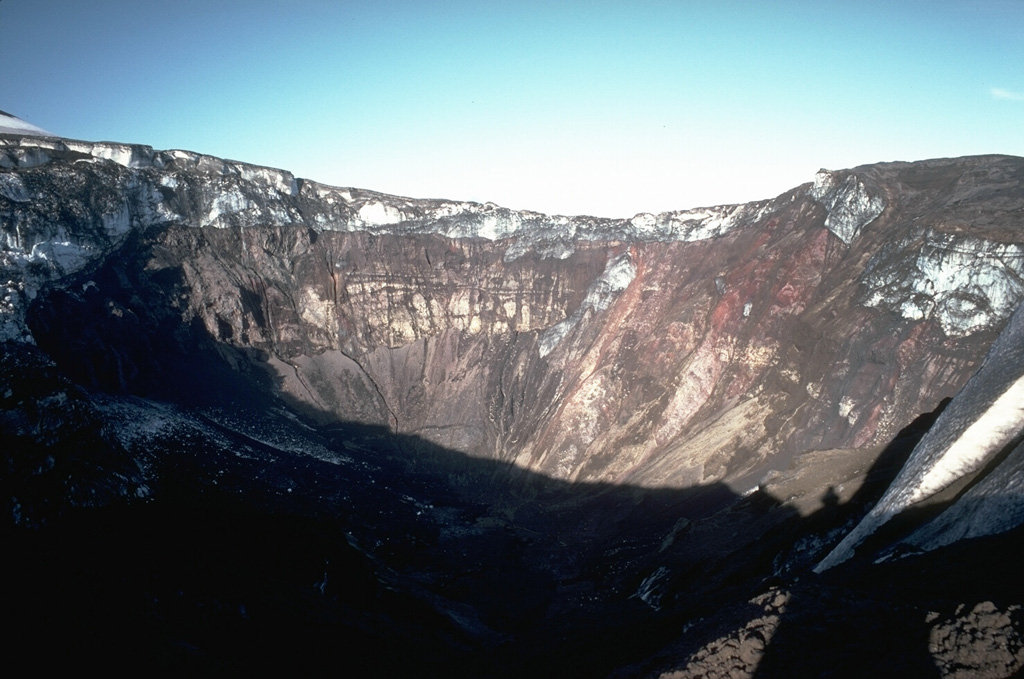 An explosive eruption February 4-9, 1978, produced an 8-10 km-high eruption column and blasted a new 1.5-km-wide, 0.5-km-deep crater through the summit icecap 1 km south of Westdahl Peak.  This view from the west rim shows the summit icefield at the top of the new crater; the icefield was truncated by the explosions. Copyrighted photo by Katia and Maurice Krafft, 1978.