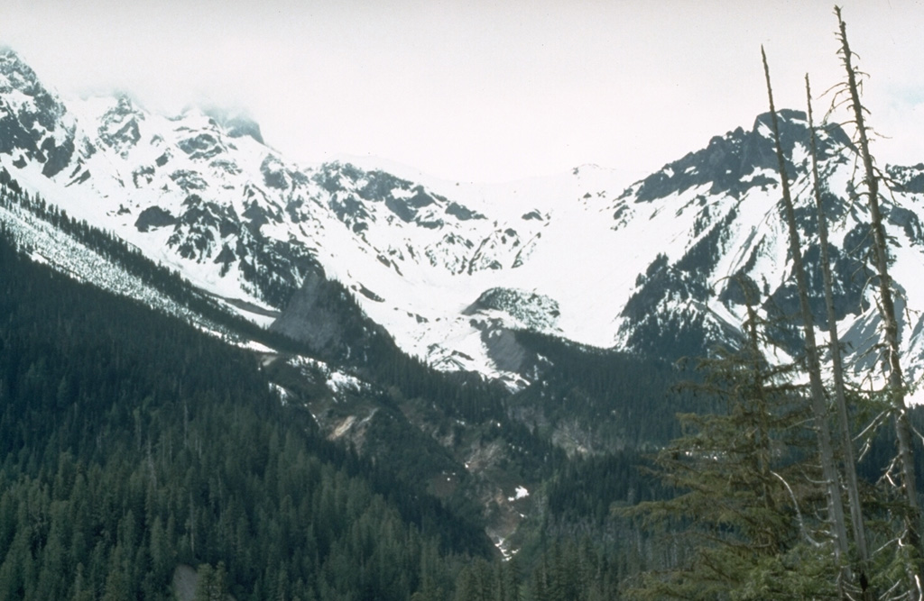 The inconspicuous ice-and-debris covered vent of the Bridge River eruption, the last eruption of the Meager volcanic complex, is located near the center of the photo immediately above the forested valley fill. The Bridge River eruption, one of the largest-known Holocene explosive eruptions in Canada, deposited ash to the east across British Columbia into Alberta. Photo by Willie Scott, 1990 (U.S. Geological Survey).