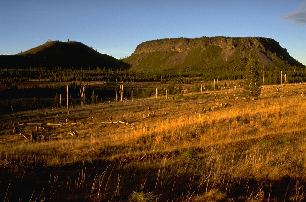 The contrasting morphology of rounded Hayrick Butte on the left and flat-topped Hoodoo Butte on the right, north of Mount Washington in the central Oregon Cascades, reflects dramatic differences in their origin. Hoodoo Butte is a "tuya," a volcanic cone formed by eruptions that ponded in a cavity melted through a glacial ice sheet. Hayrick Butte formed slightly later, when the Pleistocene ice sheet had melted, and formed the classic rounded profile of a scoria cone. Photo by Lee Siebert, 1995 (Smithsonian Institution).