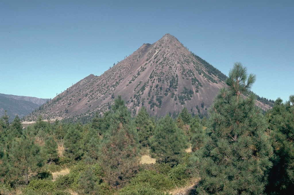 Black Buttes is a group of overlapping lava domes on the lower western flank of Mount Shasta that formed during the early Holocene, around the same time as the formation of Shastina on the upper west flank. Block-and-ash flows accompanying dome growth traveled over 10 km S. The notches on the western flank (left) mark the tops of several individual domes. Photo by Lee Siebert, 1981 (Smithsonian Institution).