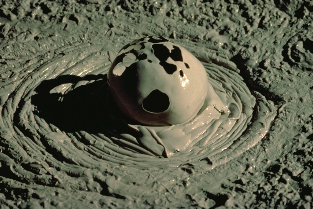 Gas escaping from a mudpot at Yellowstone creates an ephemeral spherical bubble.  Mudpots form in hydrothermal systems where the gas phase dominates the thermal system in areas of intense, clay-rich hydrothermal alteration. Copyrighted photo by Katia and Maurice Krafft, 1984.