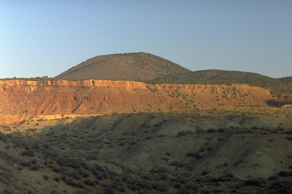 The morphologically youthful Crater Hill cinder cone near the SW boundary of Zion National Park was formed during the latest eruptions of the Kolob volcanic field at the end of the Pleistocene.  Lava flows from Crater Hill blocked the Virgin River, forming an ephemeral lake that extended past the town of Springdale into the national park.  Other cinder cones of the Kolob field to the north are of earlier Pleistocene age and fed lava flows extending 10-15 km down valleys to the south. Photo by Lee Siebert, 1987 (Smithsonian Institution).