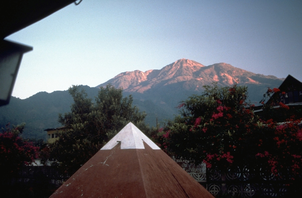 Tacaná is located along the México/Guatemala border, seen here from the SSE from the Mexican town of Unión Juárez, where it rises above the Pacific coastal plain. The elongate summit region is composed of a series of lava domes. Historical activity has included mild phreatic eruptions, but stronger explosive activity, and production of pyroclastic flows, occurred earlier. Photo by Norm Banks, 1987 (U.S. Geological Survey).