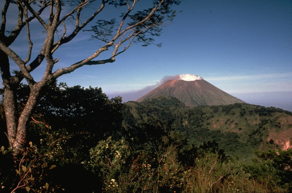 Steaming San Cristóbal volcano rises to the WNW beyond the rim of La Ollada, the 1-km-wide crater of Casita volcano.  Fumarole activity along the northern wall of La Ollada has persisted since the early 16th century and does not exceed a temperature of 100 degrees Centigrade. This photo was taken from the summit of Casita volcano. Photo by Alain Creusot-Eon, 1975 (courtesy of Jaime Incer).