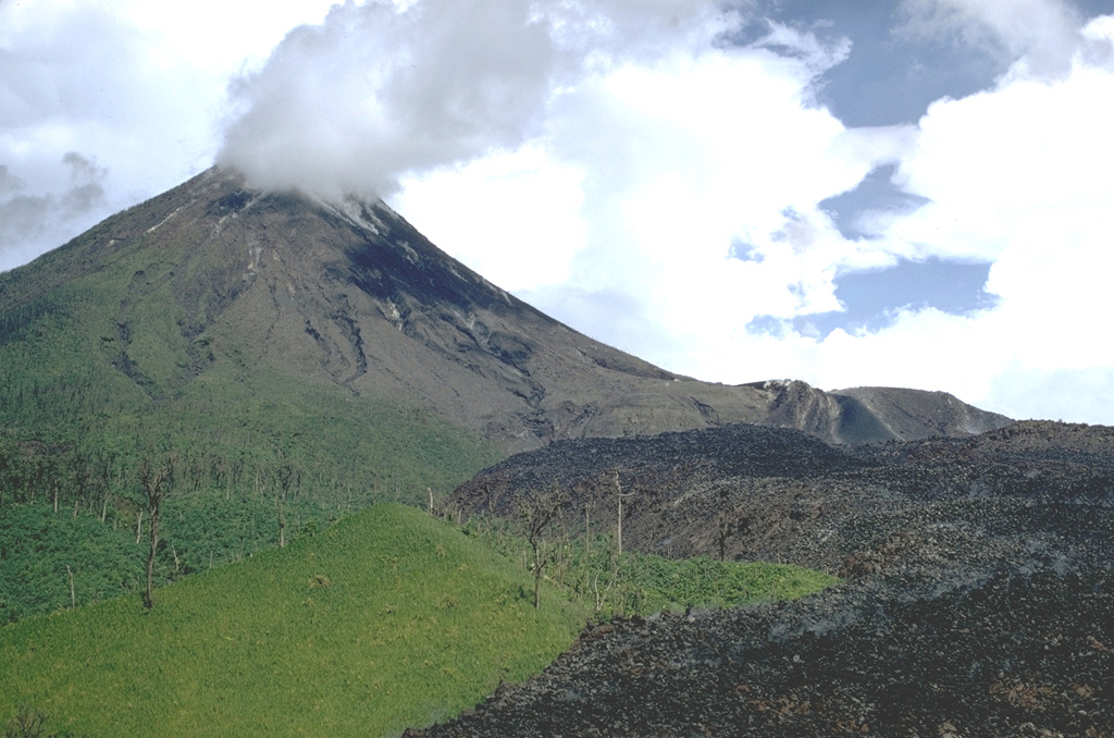 The dark lava flow at the lower right, seen here in June 1970, originated from Crater A on the lower western flank of Arenal in September 1968. Gas plumes rise from the B and C craters at the summit.  Photo by William Melson, 1970 (Smithsonian Institution).