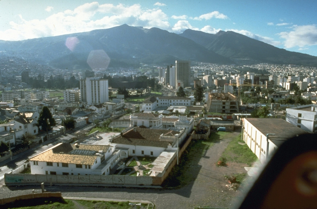 Guagua Pichincha volcano towers over Ecuador's capital city of Quito.  The historically active vent of Guagua Pichincha is located within a large, steep-walled caldera that is breached to the west, in a direction opposite the city.  This has served to funnel pyroclastic flows and mudflows away from Quito.  Most historical eruptions have been relatively minor, although an explosive eruption in 1660 dropped 30 cm of ash on the city. Photo by Norm Banks, 1988 (U.S. Geological Survey).