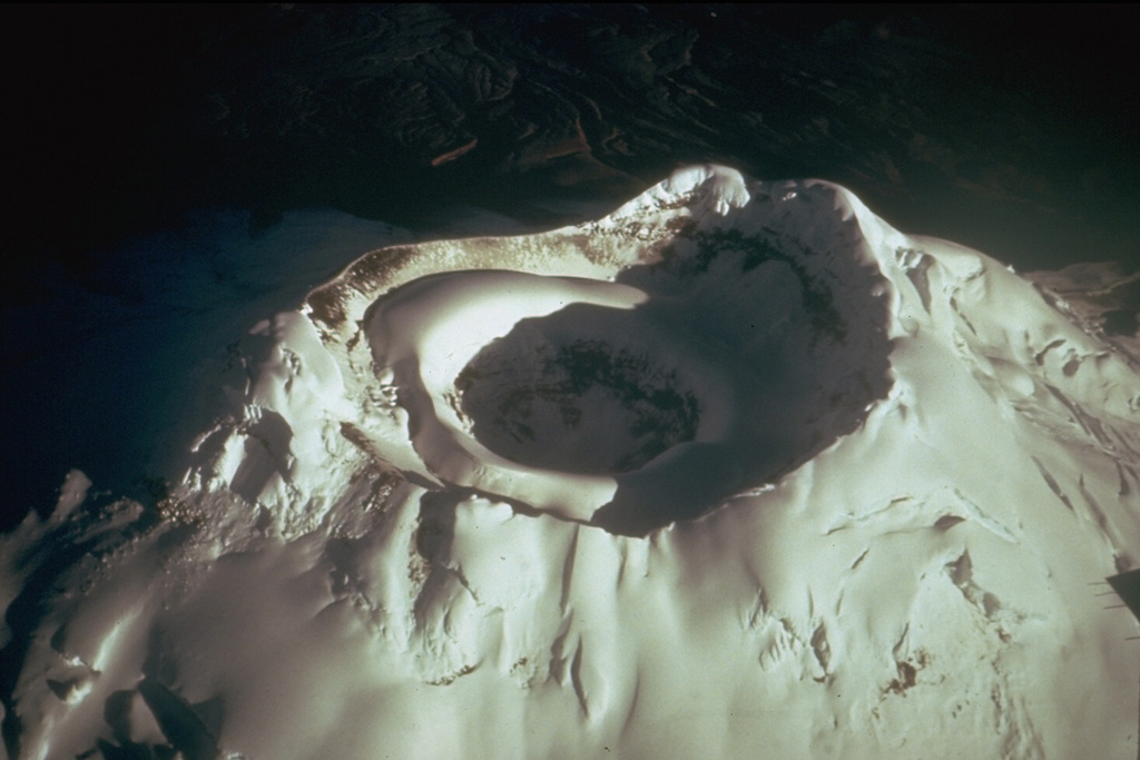 The glacier-capped summit of Ecuador's Cotopaxi volcano has two nested summit craters. The outer crater, seen here from the SE, is 550 x 800 m wide. A cone that grew inside this crater contains a smaller crater that is 250 m wide and 120 m deep. Frequent explosive eruptions during historical time have modified the shape of the summit crater. In 1903 the outer crater was 450 m deep. Photo by Tom Simkin (Smithsonian Institution).