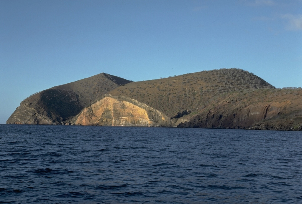 Cabo Cowan is a tuff cone at the NW tip of Santiago Island in the Galápagos Islands. Wave erosion has truncated the flanks of the cone, forming vertical sea cliffs that expose its interior stratigraphy. The cone is located where the NW-trending rift zone along the crest of Santiago shield volcano encounters the sea. Photo by Lee Siebert, 1978 (Smithsonian Institution).