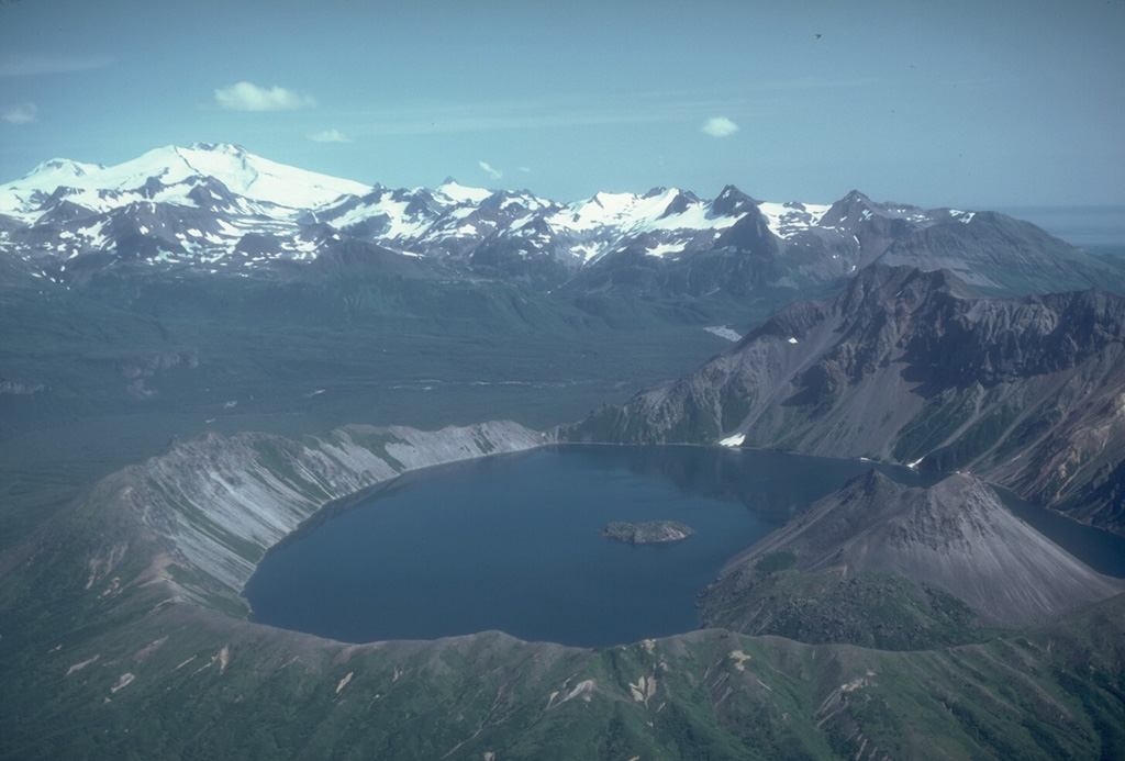 Fourpeaked volcano to the upper left is one of a group of volcanoes NE of Katmai National Park, beyond the 2.5-km-wide Kaguyak caldera in the foreground. Much of the surface is hidden beneath Fourpeaked Glacier; the few exposed outcrops are lava flows interlayered with volcanic agglomerate. Deposits near the summit are extensively hydrothermally altered. Photo by Chris Nye (Alaska Division of Geological and Geophysical Surveys, Alaska Volcano Observatory).