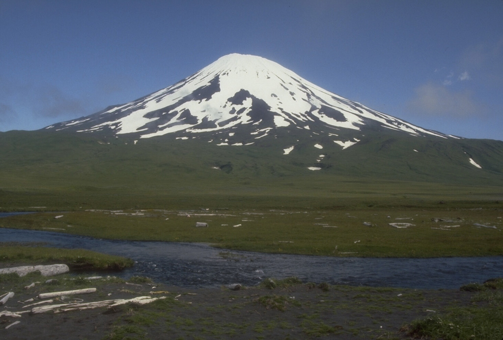 Mount Vsevidof is allocated on SW Umnak Island. The historically active volcano, seen here from the south, contains an E-W zone of scoria cones on the W flank that fed many lava flows, including a large flow that reached the west coast of the island and formed Cape Kigushimkada.  Photo by Chris Nye (Alaska Division of Geological & Geophysical Surveys).