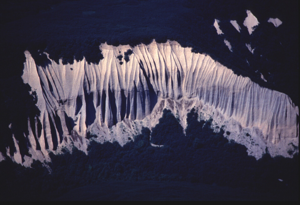 Erosion of unwelded pyroclastic flow deposits from Kurile Lake caldera formed these cliffs along the Ukanovich River, 10 km N of the caldera. Voluminous pyroclastic flows accompanying formation of the caldera about 7,600 years ago covered the area during one of the largest Holocene eruptions of the Kamchatka Peninsula. Photo by Nikolai Smelov, 1996 (courtesy of Vera Ponomareva, Institute of Volcanic Geology and Geochemistry, Petropavlovsk).