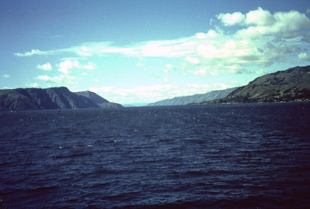 Tuk-Tuk, a small peninsula on Samosir Island, provides a vista of Latung Strait, which separates the opposing resurgent blocks of Samosir (right) and the Uluan block on the left. The Latung Strait marks the center of post-caldera resurgence, which tilted the Uluan block, located within the SE part of the caldera, to the SE and the Samosir Island block to the NE. Photo by Mike Dolan, 1993 (Michigan Technological University).