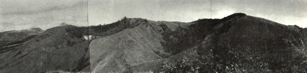 A N-S-trending chain of cones and craters in the central highlands forms the summit of Inielika volcano, seen here from the east. Ten craters, some of which contain crater lakes, occur across the complex summit region and others occupy the flanks. A phreatic explosion in 1905 formed a new crater. Photo by Ruska Hadian, 1970 (Volcanological Survey of Indonesia).