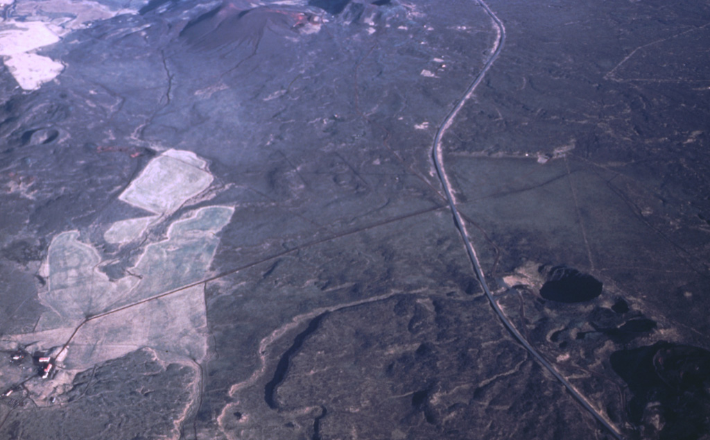 The small Grímsnes volcanic field is seen here in an aerial view from the southwest. A major road (Route 35) is seen running from the top to the bottom of the picture. To the east of this is the Tjarnarhólar crater row (bottom right), including the lake-filled Kerid Crater at the top. The Seyðishólar and Kerhóll cinder cones visible at top center formed about 9,500 and 7,050 years ago, respectively. Photo by Oddur Sigurdsson, 1991 (Icelandic National Energy Authority).