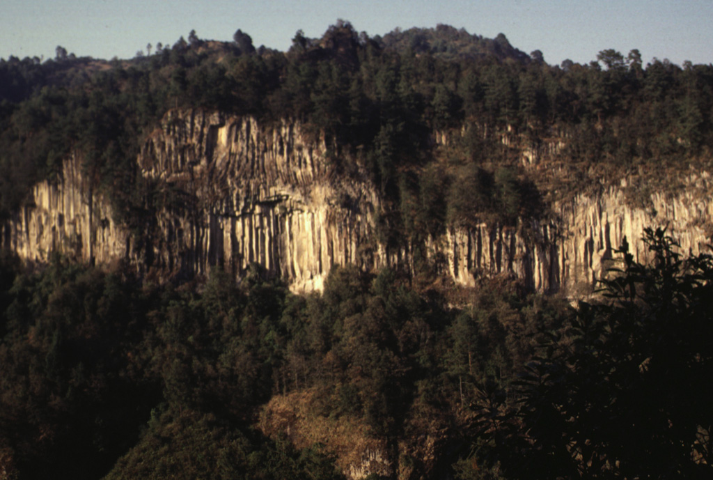 A massive columnar jointed lava flow is exposed in a valley NE of Orizaba volcano. The roughly 530,000-year-old Calcahualco lava flow was erupted during the Torrecillas stage, from the first of three major volcanic edifices forming the volcano. The source vent of this flow is now buried. Photo by Lee Siebert, 1998 (Smithsonian Institution).