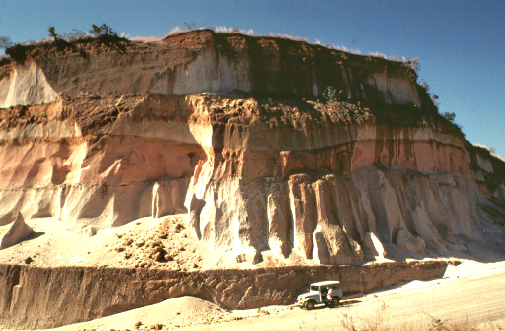 Thick units of the 84,000-year-old Los Chocoyos Ash are exposed south of Guatemala City, more than 100 km from its source at Atitlán caldera. Three units are visible here. The pinkish unit across the center of is the oxidized top of the pyroclastic flow deposit. The bottom two white units are the top and bottom halves of the deposit. The two fall deposits above the Los Chocoyos Ash are unit E from Amatitlán caldera and the younger unit C from Volcán de Agua. Photo by Bill Rose, 1978 (Michigan Technological University).