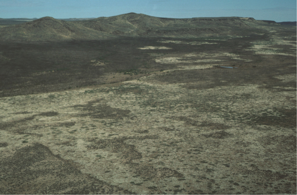 The pyroclastic cone at the upper left is the Pliocene Las Mojoneras volcano of the Camargo volcanic field.  The scarp of Las Borregas Fault is visible at the upper right and lies behind the cones.  Faulting and eruptive activity were closely linked throughout the evolution of the Camargo volcanic field. Photo by Charles Conner, 1997 (Southwest Research Institute).