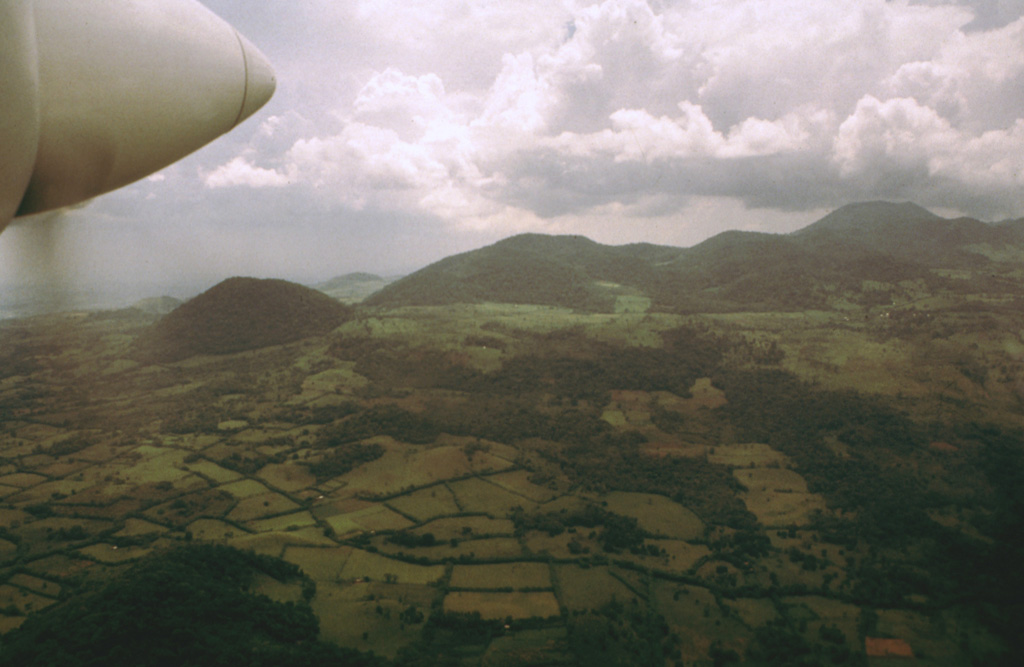 An aerial view from the SE shows cones on the flank of the massive San Martín Tuxtla volcano. More than 250 cones and maars are found on the flanks, mostly along a 40-km-long NW-trending zone parallel to the elongation of the edifice. Many clusters of cones are aligned in this same direction. Photo by Hugo Delgado-Granados, 1997 (Universidad Nacional Autónoma de México).