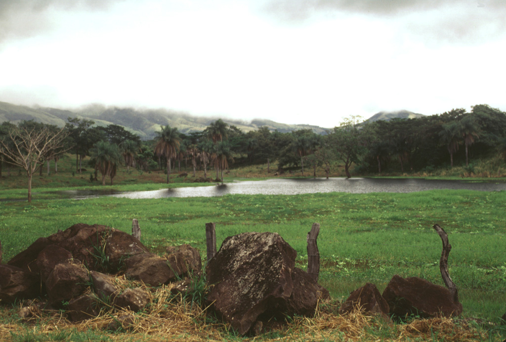 This topography south of Miravalles volcano is typical of that resulting from large volcanic debris avalanches and represents material produced by major edifice collapse. Large boulders are abundant, such as those in the foreground.  Photo by Lee Siebert, 1998 (Smithsonian Institution).