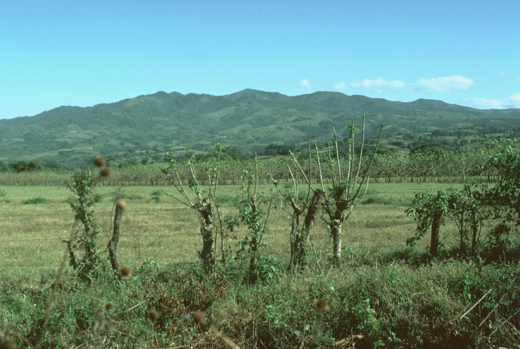 The eroded Plio-Pleistocene Ixhuatán volcano rises to the NE above the Pacific coastal plain of Guatemala.  Ixhuatán has produced dominantly andesitic lava flows and volcaniclastic deposits.  NE-SW-trending faults cut the volcanic complex.  Pleistocene andesitic ignimbrite deposits from the neighboring Tecuamburro volcanic complex bank up onto the western flanks of Ixhuatán. Photo by Lee Siebert, 1988 (Smithsonian Institution).