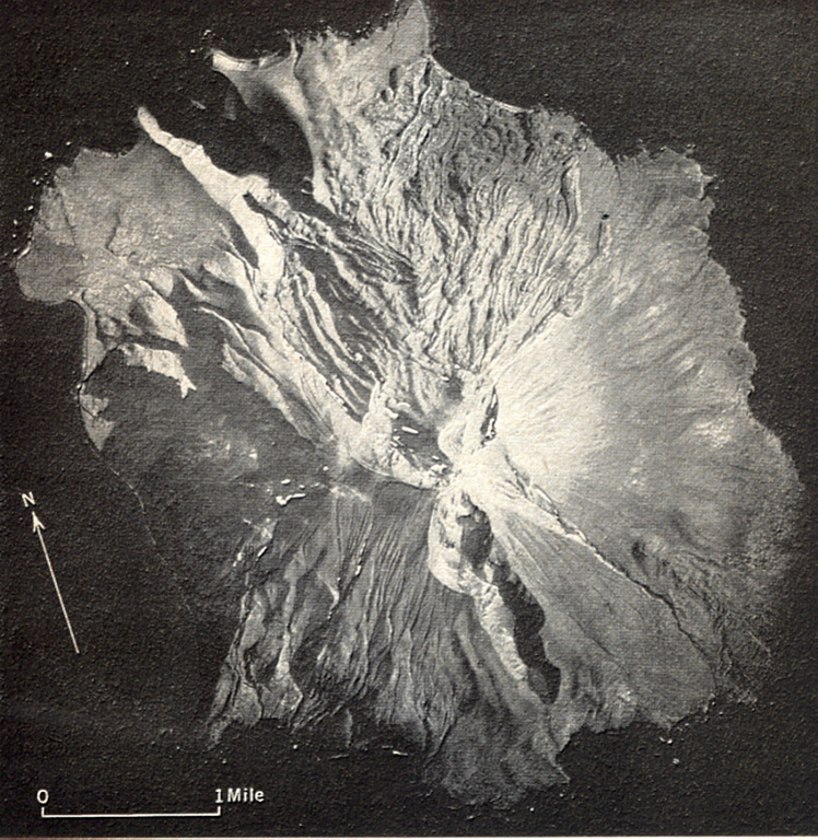 A prominent N-S-trending fissure that extends to sea level at both ends across Segula, located near the western end of the Aleutian Arc. The irregular topography on the N side of the island is an extensive lava field that erupted from the summit crater along the NE flank to the coast. A smaller lava field to the lower right originated from a scoria cone on the lower SE flank. A scoria cone constructed along the S rim of a small caldera forms the high point of the island. Photo by U.S. Air Force (published in U.S. Geological Survey Bulletin 1028-K).