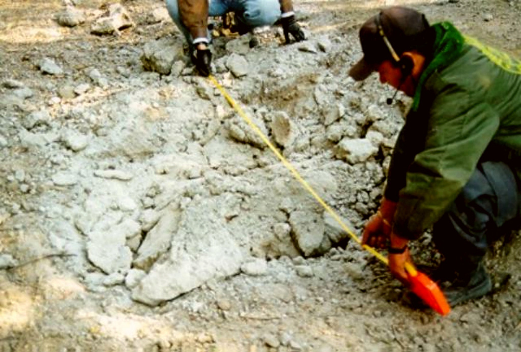 Scientists measure a shattered block ejected during Colima's 10 February 1999 explosion. Several impact craters were measured about 3 km NE of the summit, including from this block, which landed on the road to the caldera. This was the biggest explosion reported for the volcano in the previous 80 years. A substantial number of incandescent blocks started fires on the upper flanks. Photo courtesy of F. Núñez-Cornú, G. Reyes-Davila, and C. Suárez-Plascencia, 1999 (University of Guadelajara).