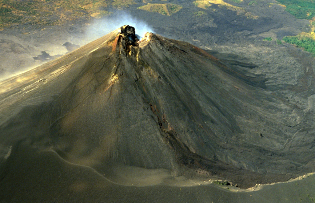 The degassing MacKenney cone summit crater of Pacaya is shown in this February 1999 aerial view from the north. A trail in the foreground is along the rim of a large horseshoe-shaped crater inside which the cone was constructed. Lava flows from the summit crater and flank vents of MacKenney cone have traveled into the moat and subsequently been deflected to the west and south. Copyrighted photo by Stephen and Donna O'Meara, 1999.