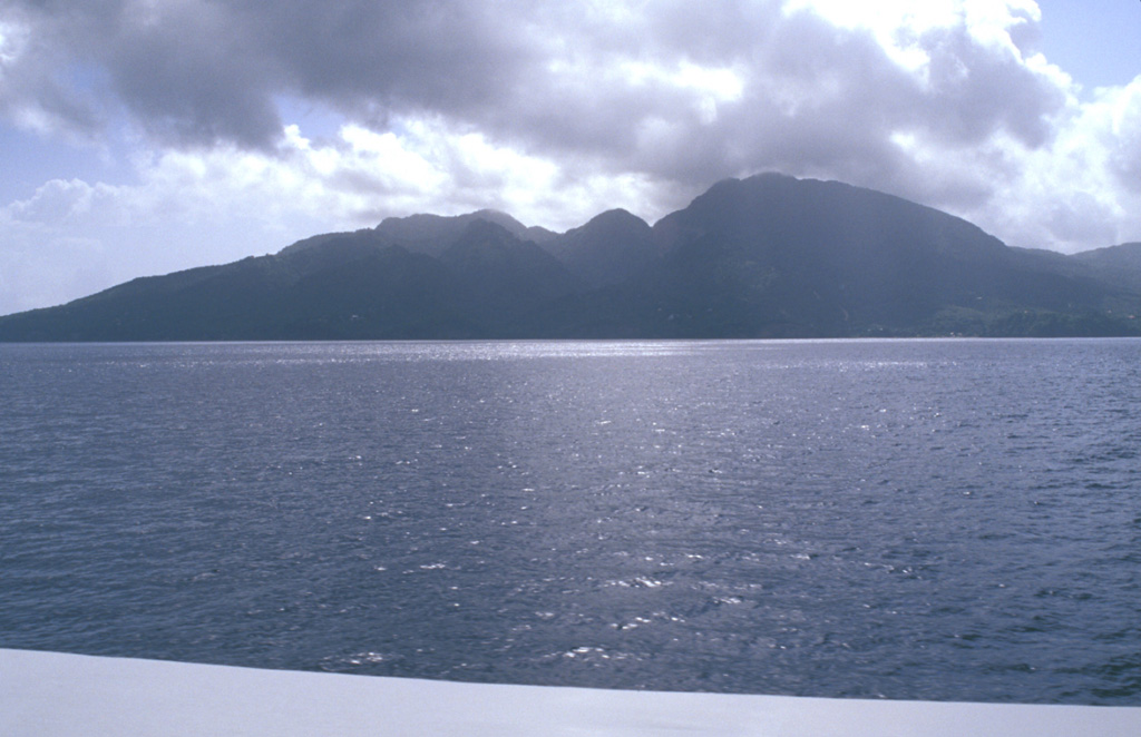 Morne aux Diables volcano at the northern tip of Dominica is a stratovolcano composed of andesitic lava domes, lava flows, and block-and-ash flow deposits well exposed in coastal sea cliffs.  Volcanism at the dominantly Pleistocene Morne aux Diables is considered to have likely continued into the Holocene; unconsolidated block-and-ash flow deposits extend to the NW and NE coasts.  Fumarolic areas are present on the volcano, and the Penville Cold Soufrière, an area of bubbling pools, lies within the youngest crater of the volcano.    Photo by Lee Siebert, 2002 (Smithsonian Institution).