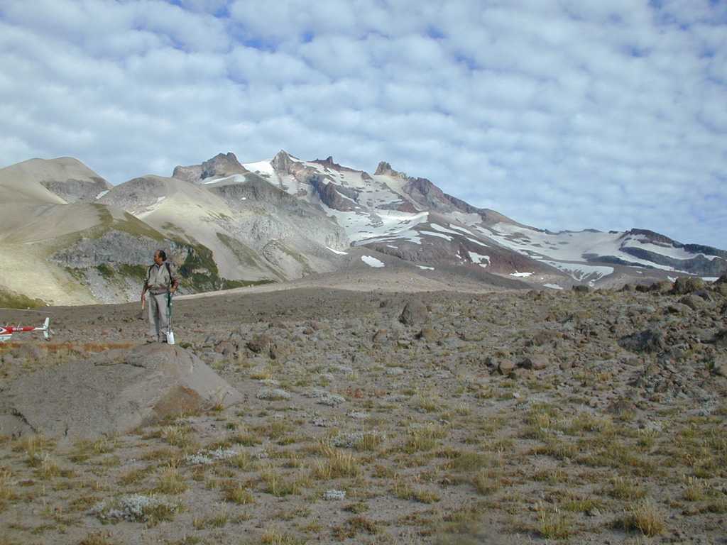 The conical, glacier-clad Nevado de Longaví volcano is seen from the SE.  In the foreground is a Holocene block-and-ash flow deposit.  This late-Pleistocene to Holocene andesitic stratovolcano was constructed over a basement of sedimentary and granitic rocks.  A small lava dome forms the 3242-m-high summit of Longaví.  No historical eruptions are known, although fumarolic activity continues.      Photo by José Naranjo, 2001 (Servico Nacional de Geologica y Mineria).