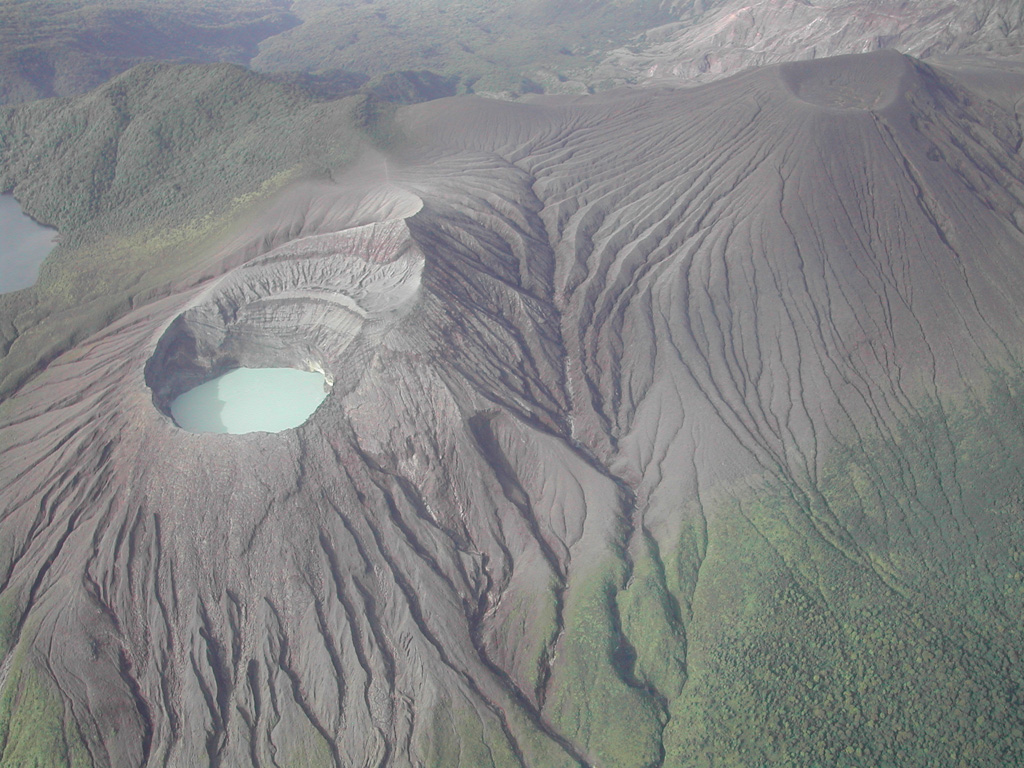 The flanks of Von Seebach cone (upper right) are a result of tephra and acidic gases blown downwind from the lake-filled Cráter Activo (left). Steady trade winds from the NNE distribute gas from Active Crater to the SW, creating the "Dead Zone" that extends down the SW flanks to the upper right. Photo by Eliecer Duarte (OVSICORI-UNA).