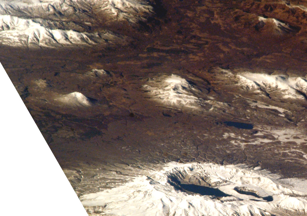 Ksudach is the volcano with multiple crater lakes at the bottom of this NASA International Space Station image (with N to the right). The smaller snow-covered cone near the left-center is the 700-m-high Holocene Belenkaya volcano. NASA International Space Station image ISS005-E-19216, 2002 (http://eol.jsc.nasa.gov/).