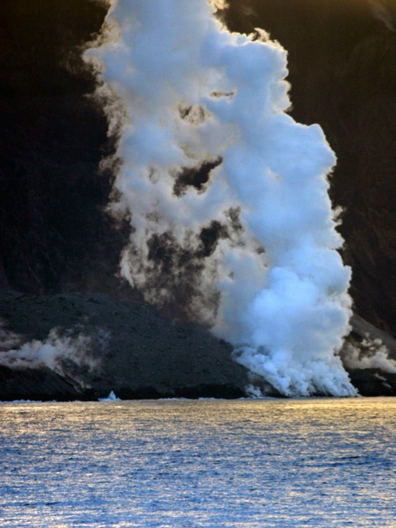 Steam rises from lava flows entering the ocean on the north side of Montagu Island on 13 January 2006. Satellite imagery showed that the lava flow had reached the north coast in September 2005 and began forming a new lava delta. Photo courtesy of Dave Hall, Frikkie Viljoen and Ian Hunter, 2006 (SA Argulhas and South African Weather Service.