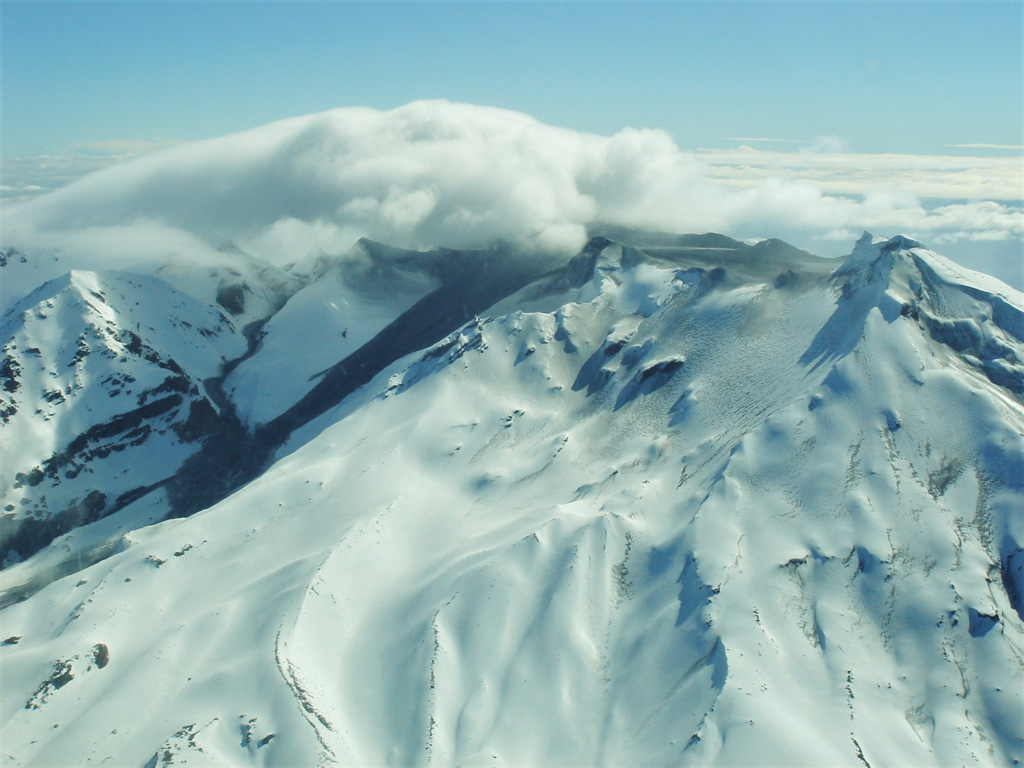 The 25 September 2007 eruption of Ruapehu produced lahars on the N and E flanks from Crater Lake, with the E flank lahar seen here. Two lahar descent paths are visible, the wider one closer to the center down the Whangaehu Glacier, and the narrower path further to the left down the Whangaehu valley. The lahar merged and continued for 200 km along the Whangaehu River. Photo by Janine Krippner, 2007.