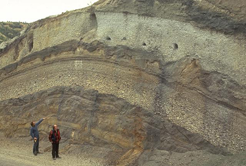 Volcanologists Colin Wilson and Peter Ballance examine a roadcut that dissects deposits of major eruptions from the Taupo volcanic center.